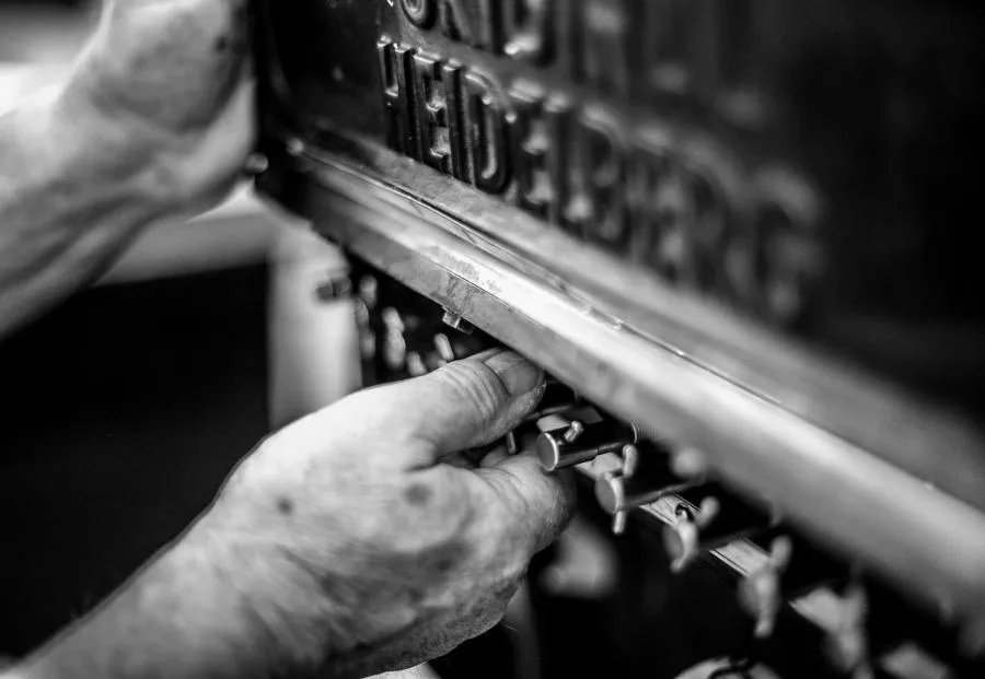 Close Up von Händen die die Zonenschrauben der Druckmaschine einstellen.