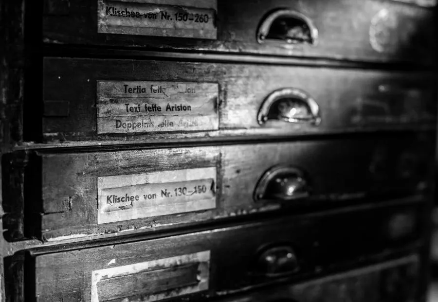Vier alte und flache Holzschubladen zur Aufbewahrung von Klischees und Bleilettern.